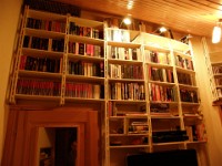 Weisses Bücherregal für die Wand  Richtig heimelig wirkt das weiß lackierte Bücherregal in diesem warmen Licht und es ist nicht schwer vorstellbar wie wohl man sich hier an langen Winterabenden fühlt und die Zeit mit lesen am Kaminfeuer verbringt.